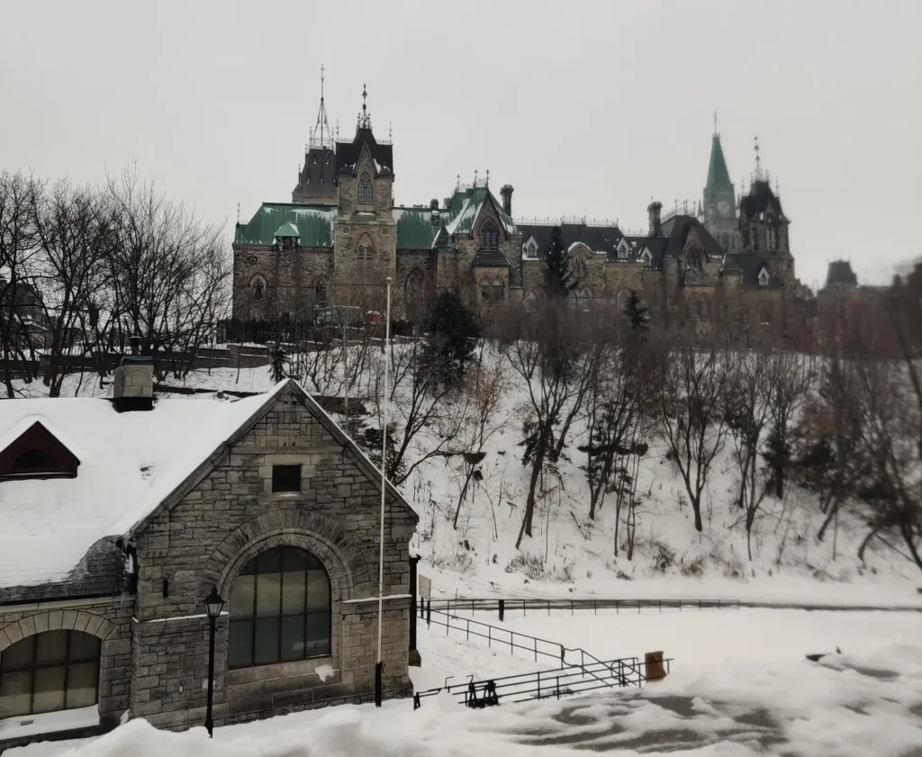 Parliament Hill in Ottawa in winter, seen from below, with the Peace Tower rising behind Gothic Revival buildings